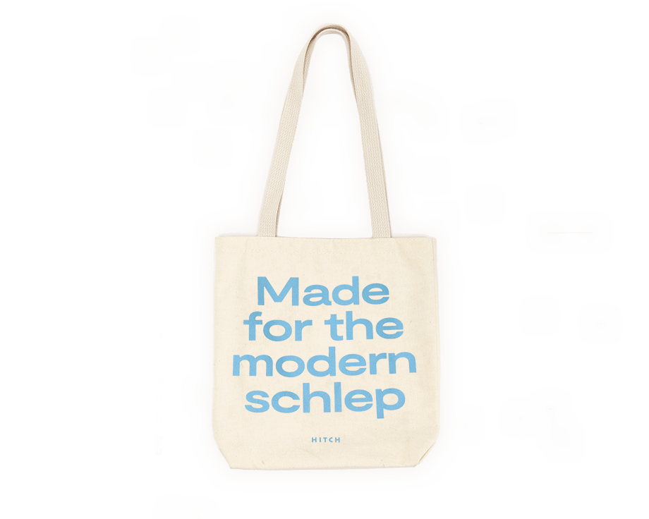 Canvas Tote with shoulder strap, the text says Made for the modern schlep in a pale blue font